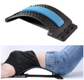 De Fashiongirl Pro Back Stretcher, die alleen met een blauw kussen wordt getoond, wordt ook gedemonstreerd door een persoon die een zwart shirt en een blauwe spijkerbroek draagt en het gebruikt voor lendensteun en houdingscorrectie.