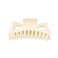 De SOHO Astrid Hair Claw - White van SOHO is een grote plastic haarclip met brede, gebogen tanden en twee driehoekige uitsparingen aan de bovenkant, ideaal voor het vastzetten van dik haar.