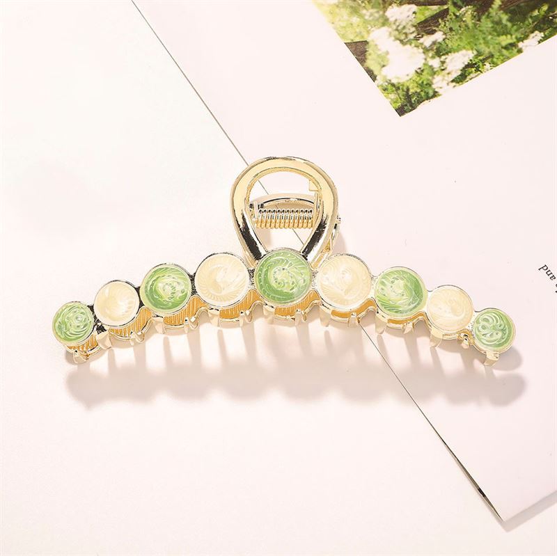 The SOHO Becca Hair Claw - Lime features a chic gold design with alternating green and cream circular stones, making it a stylish SOHO accessory for securing your hairstyle.