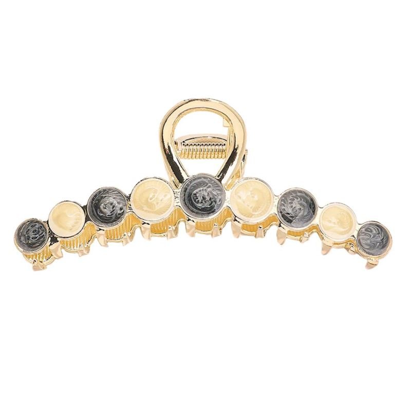 The SOHO Becca Hair Claw - Midnight features a gold metal design with alternating round beige and dark gray accents along the top, perfect for securing a messy bun.