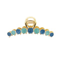 De SOHO Becca Hair Claw - Ocean van SOHO heeft een gouden metalen ontwerp met afwisselend ronde blauwe en turquoise steentjes langs de rand, ideaal om je kapsel vast te zetten.