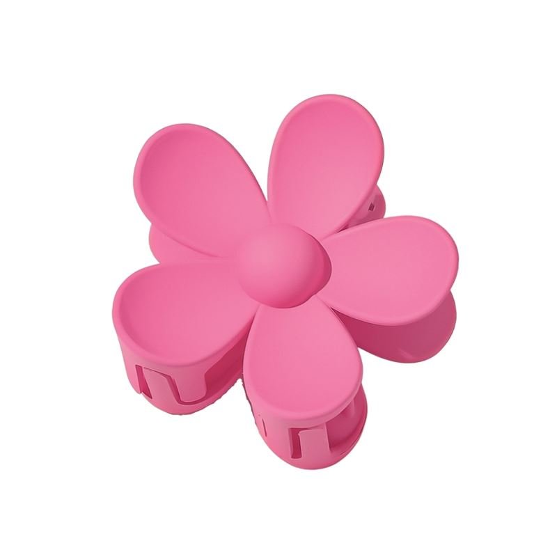 The SOHO Bloom Hair Claw - Pink by SOHO features a cute six-petal pink flower design with a central button, shown from above on a plain white background.