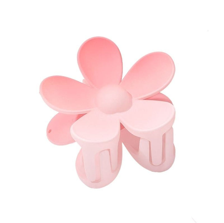 The SOHO Bloom Hair Claw in Pink Ombre, featuring five pink petals, is perfect for quick updos and is displayed against a white background.