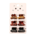 De SOHO Fika Mini Hair Claws van SOHO bestaan uit zes kleine haarspeldjes in geel, bruin en zwart, die per paar op een kaartje met een schattige kattenillustratie zijn gerangschikt. Perfect voor dagelijkse haarstyling.