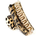 De SOHO Hair Claw - Leopard van SOHO is een grote goud-zwarte clip met een luipaardmotief, gemaakt van duurzaam acrylplastic en voorzien van gebogen tanden voor een stevige grip.