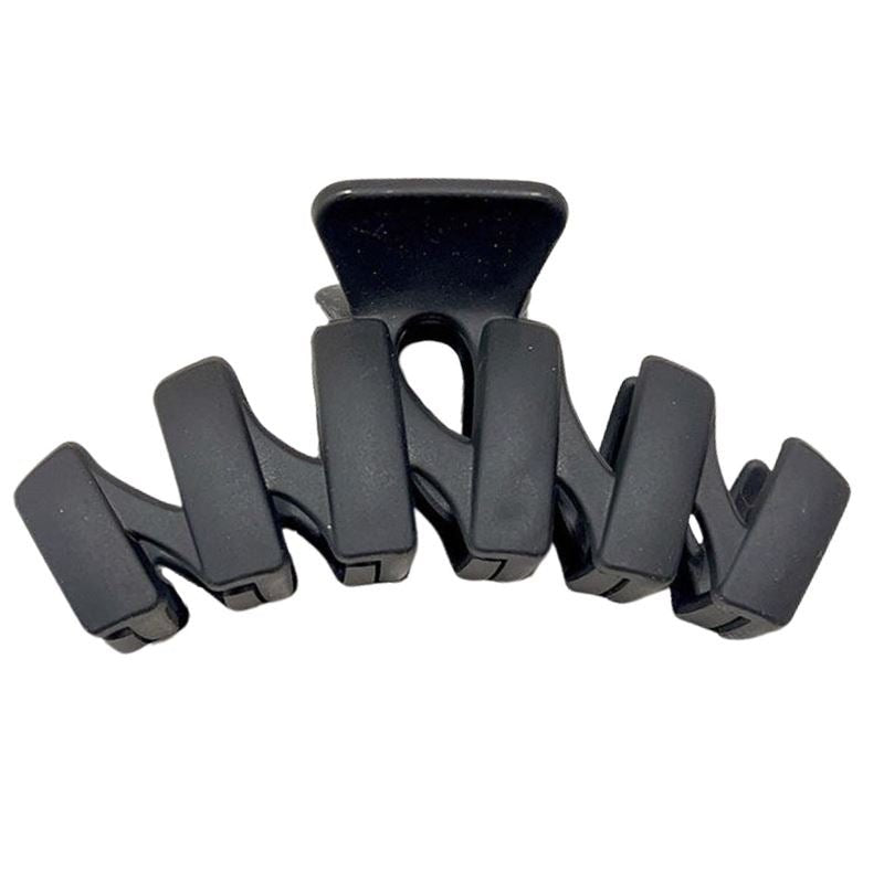 The SOHO Just Hair Claw - Black by SOHO features five wide, curved prongs for a secure hold and sleek style, making it the perfect accessory to keep your hair in place.