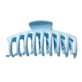 De SOHO Kana Hair Claw in lichtblauw heeft brede, gebogen tanden voor een sterke grip en is geschikt voor alle haartypes. Afgebeeld tegen een witte achtergrond.