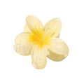 De SOHO Moana Hair Claw - Yellow is een lichtgele, bloemvormige haaraccessoire van SOHO met vijf glanzende bloemblaadjes en een veersluiting, geïnspireerd op de plumeria-bloem – ideaal als zomeraccessoire.