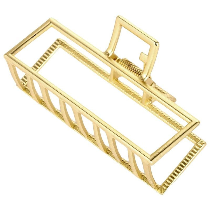 The SOHO Niba Large Metal Hair Claw in gold features open bars and a spring hinge, offering a secure hold for messy buns—ideal for stylish, effortless looks.