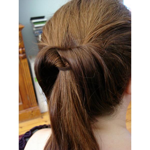 A close-up shows a neatly twisted ponytail, styled with the Fashiongirl Topsy Tail Hair Styling Tool—2 Piece Set, and secured with hair wrapped around the base for an elegant updo.