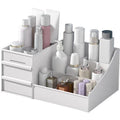 De UNIQ Cosmetic Organiser met twee lades in wit biedt ruimte om huidverzorgings- en cosmeticaproducten in flessen, potjes en tubes netjes op te bergen in meerdere compartimenten, met twee kleine lades aan de linkerkant.
