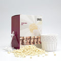 De UNIQ Nose Wax Kit van UNIQ maakt het verwijderen van neushaar eenvoudig met witte waxkorrels, plastic applicators, papieren bekertjes en een leuke verpakking met expressieve gezichten en de tekst 'Nose Wax Kit'.