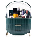 De UNIQ Retro Makeup Box Organiser in Dark Mint/Dark Green heeft twee geribbelde lades, gouden handgrepen en poten, en een doorzichtige koepelvormige deksel om je huidverzorgings- en make-upproducten netjes op te bergen.