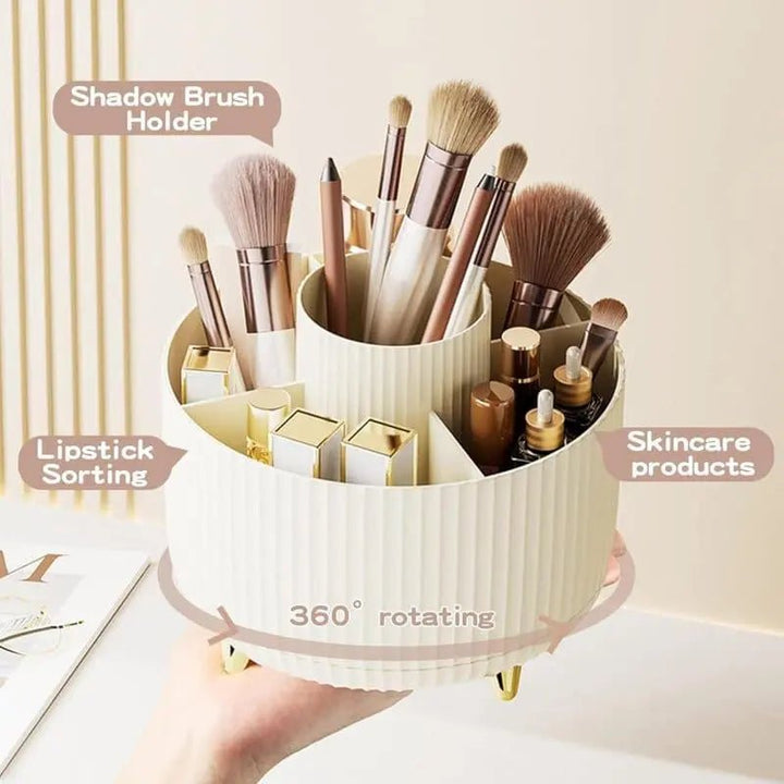 A hand holds the UNIQ Rotating Makeup Organiser in Cream White by UNIQ, featuring labeled sections for brushes, lipsticks, and skincare. This stylish organiser spins 360° for easy access and elegant storage of all your beauty essentials.